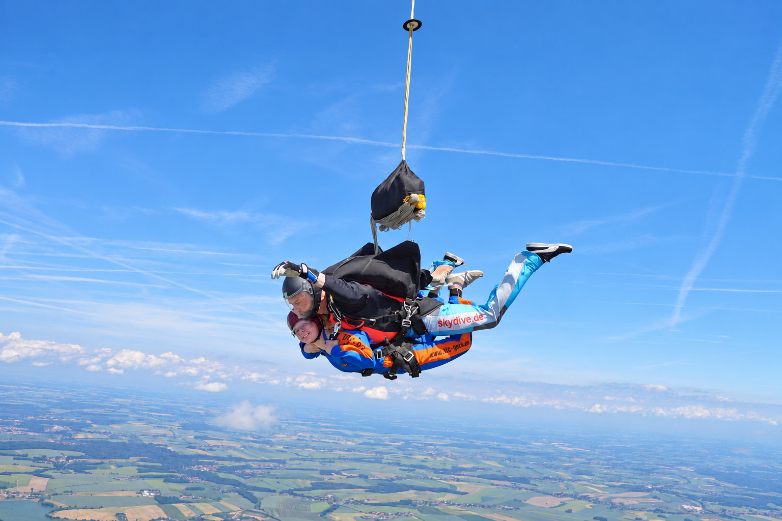 Tandemteam über der Landschaft während der Öffnung des Fallschirms